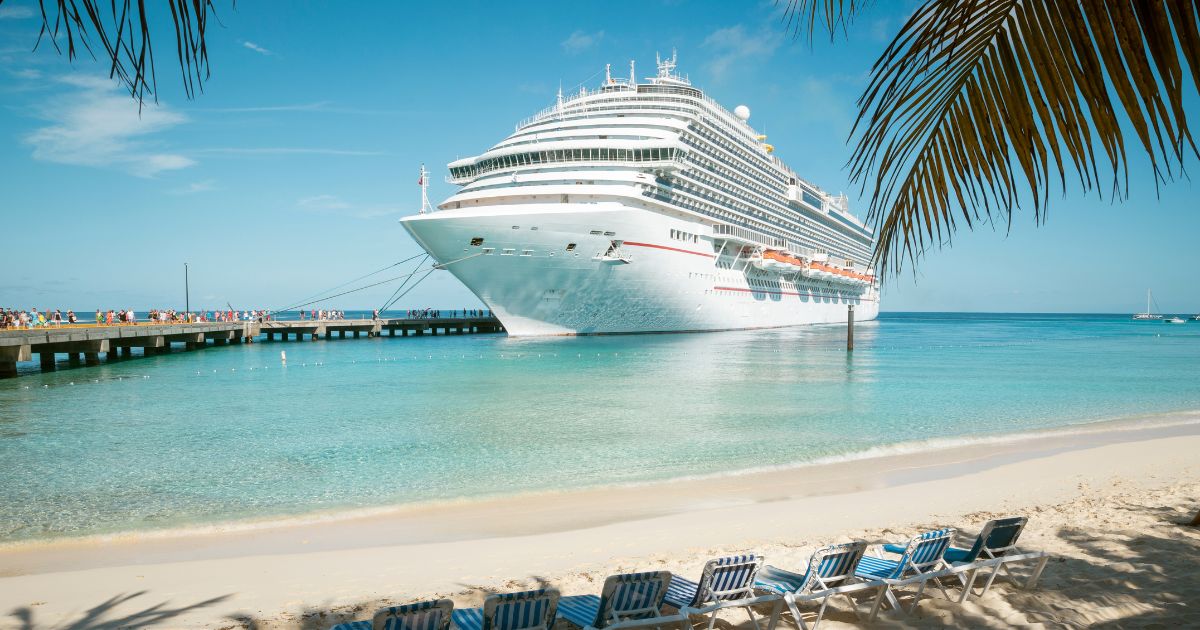 A cruise ship docked at a beach destination.